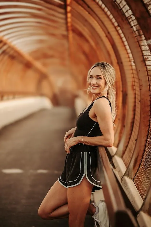 Lindsey Black, founder of Legacy Physiques, smiling confidently in a black dress, representing women's body recomposition and strength coaching for women 35 and older.