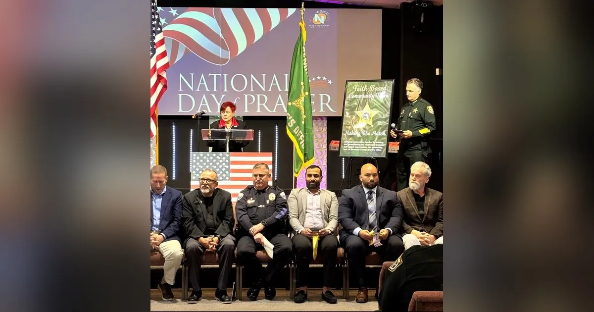 Community and law enforcement leaders seated on stage at a National Day of Prayer gathering