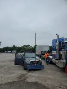 High pole escort vehicle with certified height pole preparing for oversize load transport at staging area.