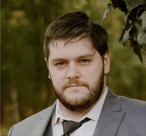 Bailee Maradeo, MSW Social Work Intern at Prebble Counseling Services, standing outdoors in a gray suit with a steady, welcoming expression.