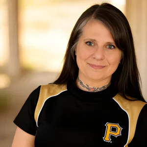 Chris Prebble, LPC, smiling in a black and gold Pittsburgh Pirates shirt with a soft-focus outdoor background