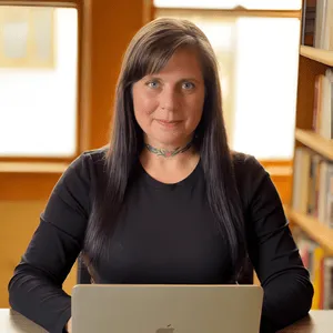 Chris Prebble, Licensed Professional Counselor, sitting at a desk with a laptop in a warmly lit office with bookshelves