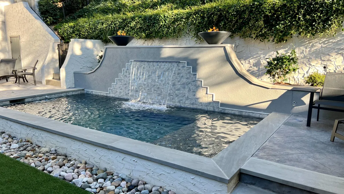 Modern luxury backyard pool with stone steps, spacious patio, fire pit seating, and contemporary home exterior in Arcadia Subdivision in East Tennessee.
