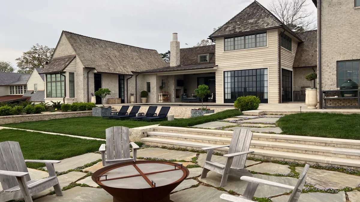 Modern luxury backyard pool with stone steps, spacious patio, fire pit seating, and contemporary home exterior in Arcadia Subdivision in East Tennessee.