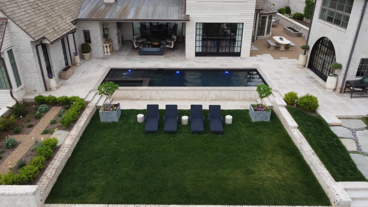 Modern luxury pool design with sleek rectangular shape, surrounded by manicured lawn, stone hardscape, and minimalist decor. Sequoyah Pools project in Arcadia in East Tennessee.