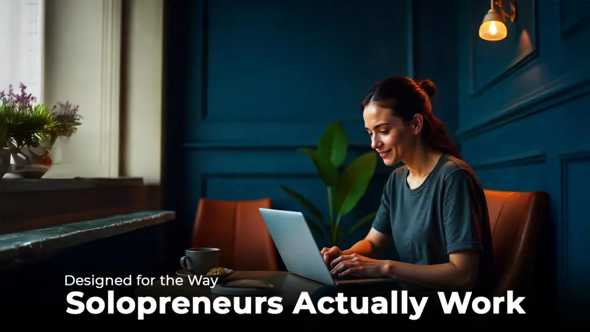 Woman working on a laptop in a café with text “Designed for the Way Solopreneurs Actually Work.”