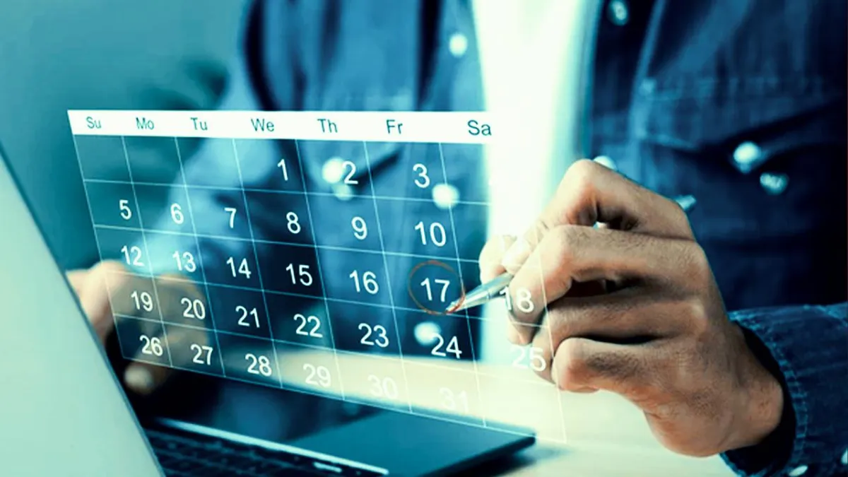 Close-up of a person marking a date on a digital calendar overlay beside a laptop.