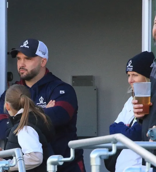 Coach/Fan standing in the stands of a rugby game