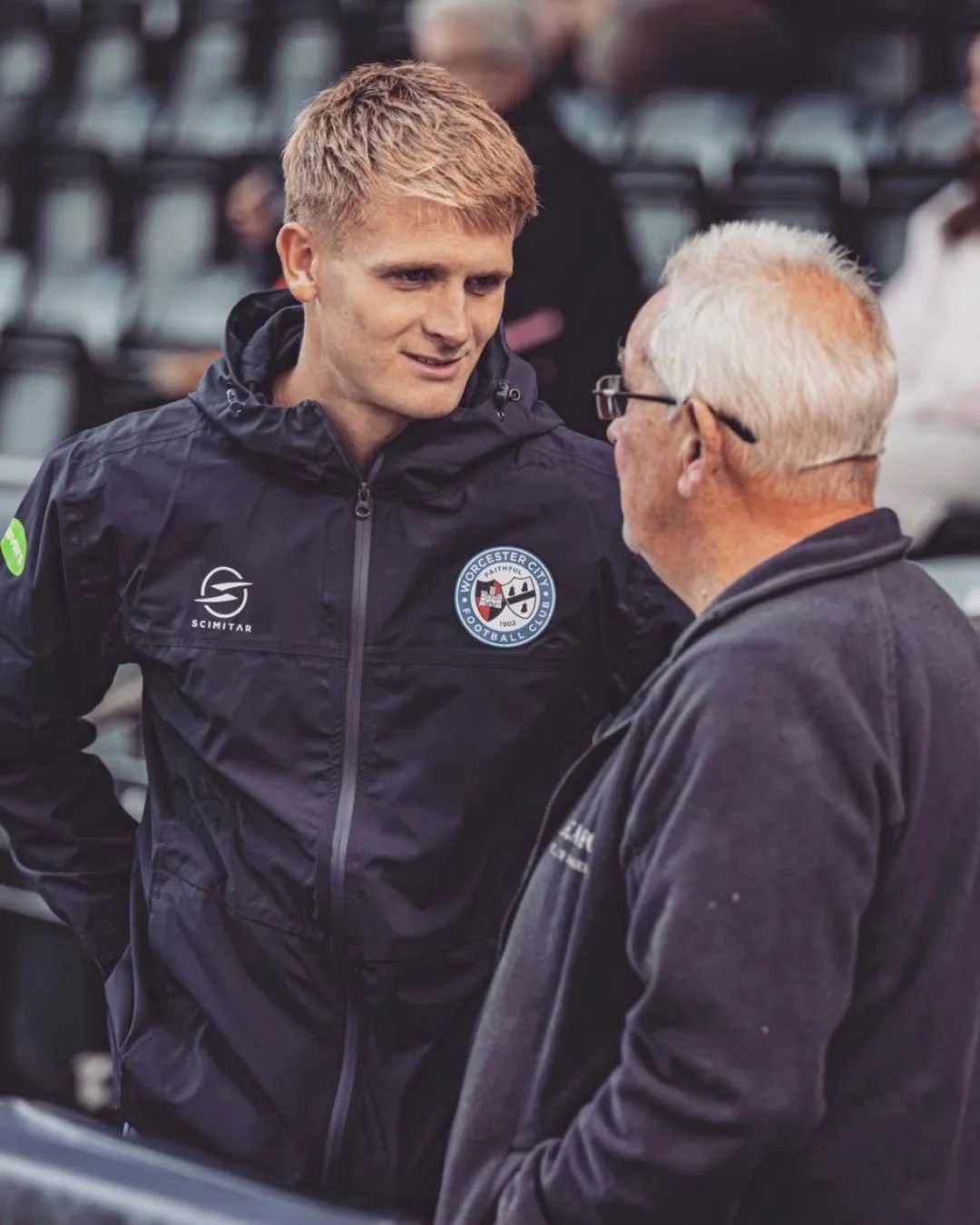 Coach/Fan standing in the stands of a rugby game