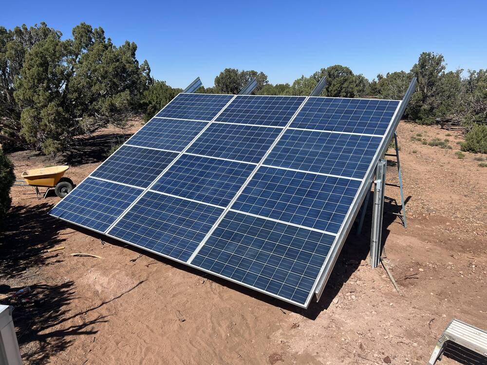 Ground-mounted solar array installed among juniper trees in the Arizona high country
