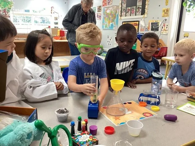 Boy and students doing science experiments in classroom