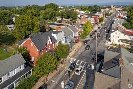 Aerial view of a small town street lined with residential houses and local businesses.