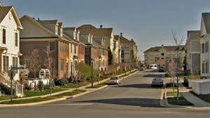 Suburban neighborhood street with modern townhomes and well-kept sidewalk