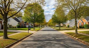 Tree-lined residential street with well-kept homes and sidewalks in a quiet neighborhood