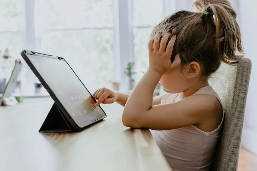Child practicing reading during online tutoring