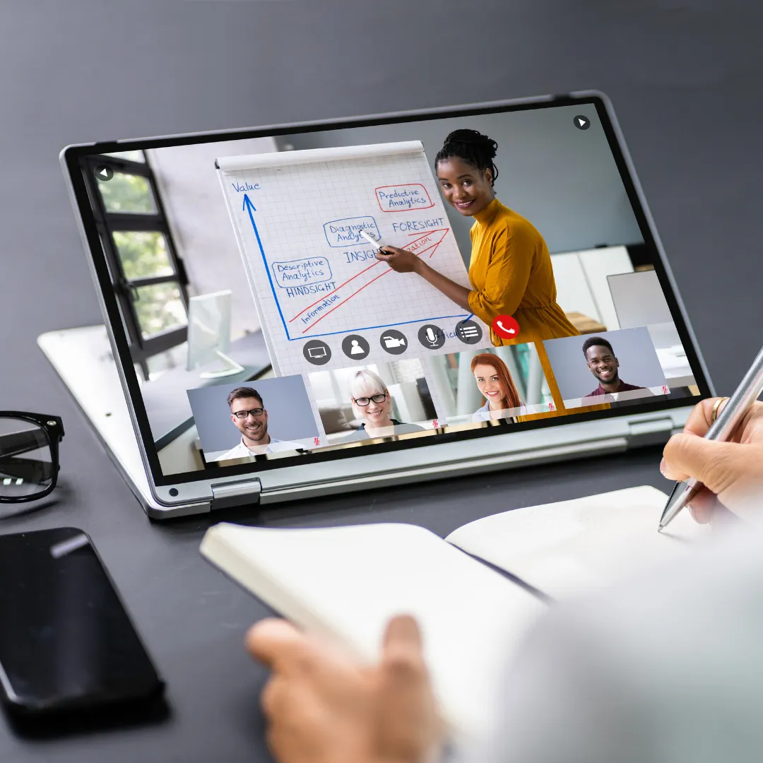 Woman presenting on a digital whiteboard during a virtual workshop, discussing analytical methods with participants visible on screen, emphasizing community learning and support for Christian entrepreneurs.
