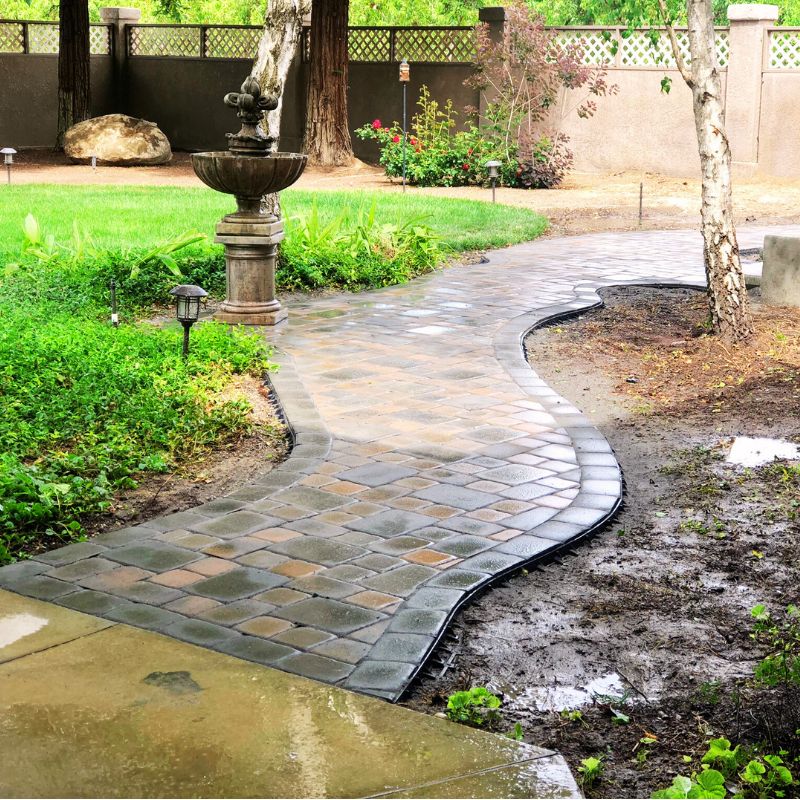 Elegant interlocking paver walkway leading through landscaped garden in Wake County home