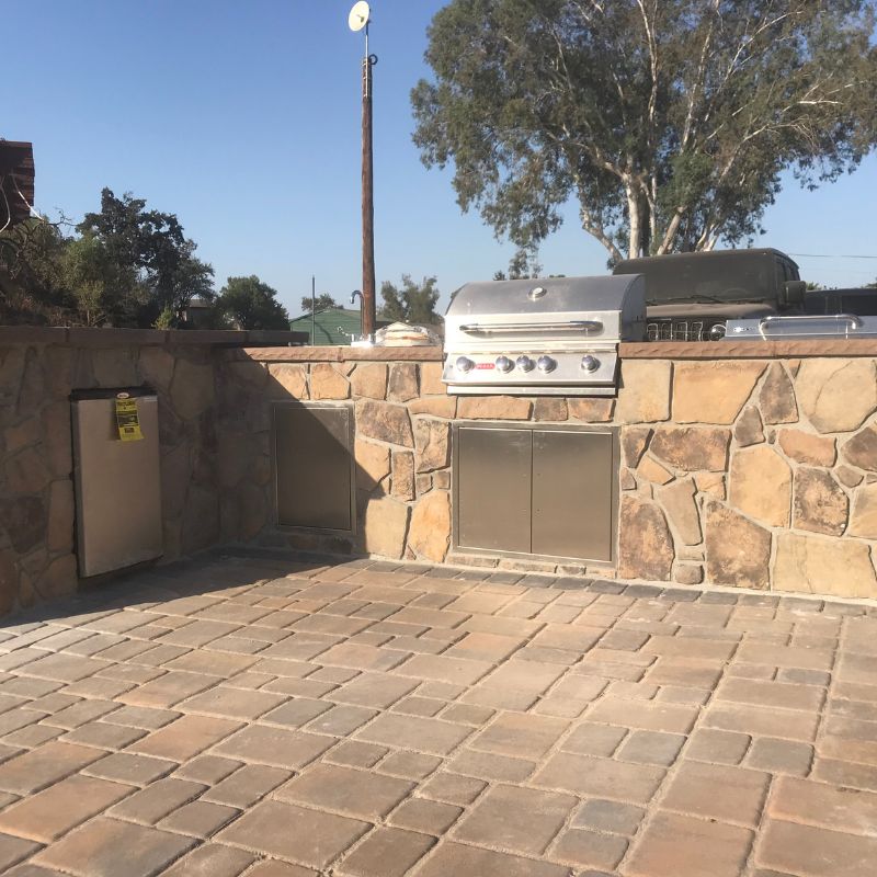 Custom stone grill island with built-in BBQ for outdoor cooking enthusiasts in Raleigh NC