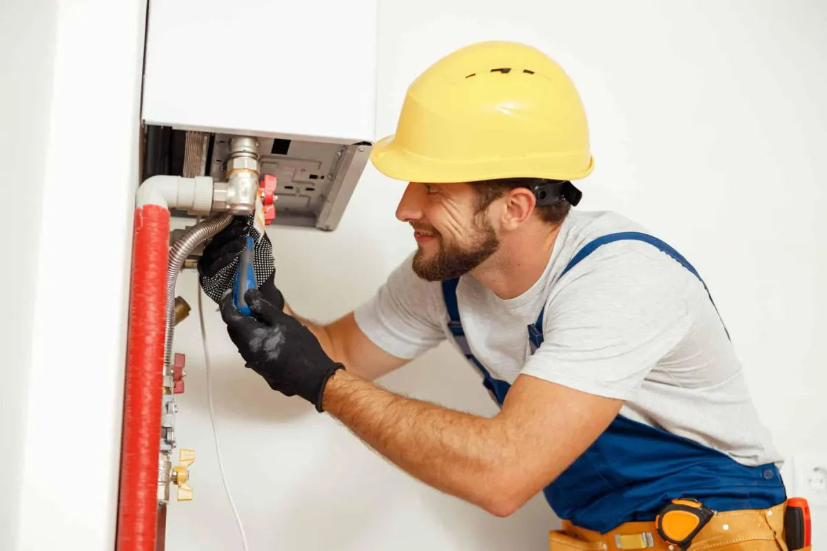 Technician wiring an electric water heater during installation.