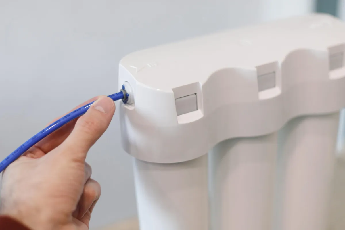 Close-up of a hand adjusting a home water filtration system.