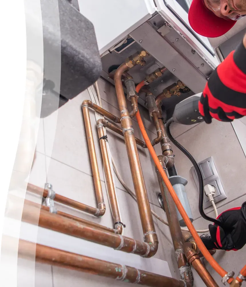 Technician inspecting copper gas lines for potential gas leak using a detection tool 