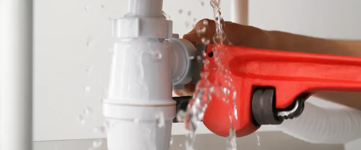 Close-up of emergency leak repair on kitchen plumbing pipe