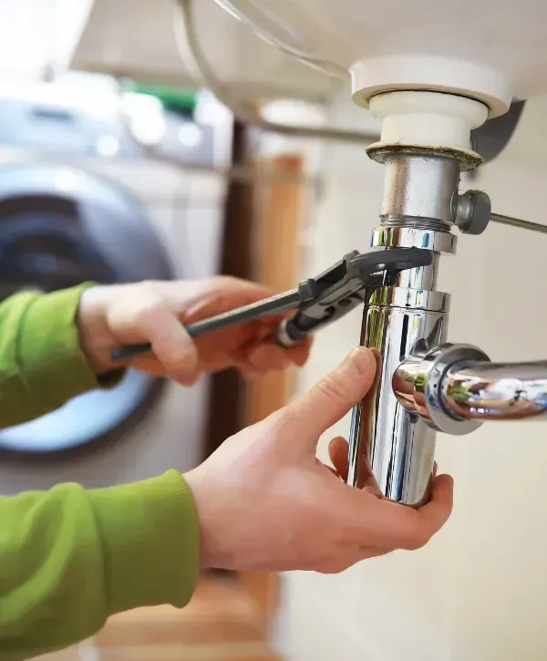 Plumber fixing sink drain with a wrench