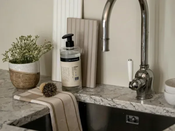 Modern kitchen sink with marble countertop and soap dispenser