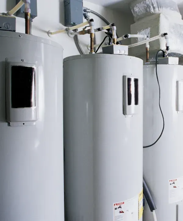 Multiple large commercial water heaters installed in a utility room