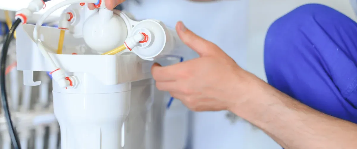 Plumber servicing a reverse osmosis water filtration system