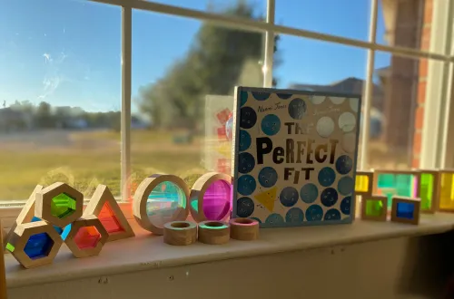 Girl stretches to the side while watching teacher on large screen TV