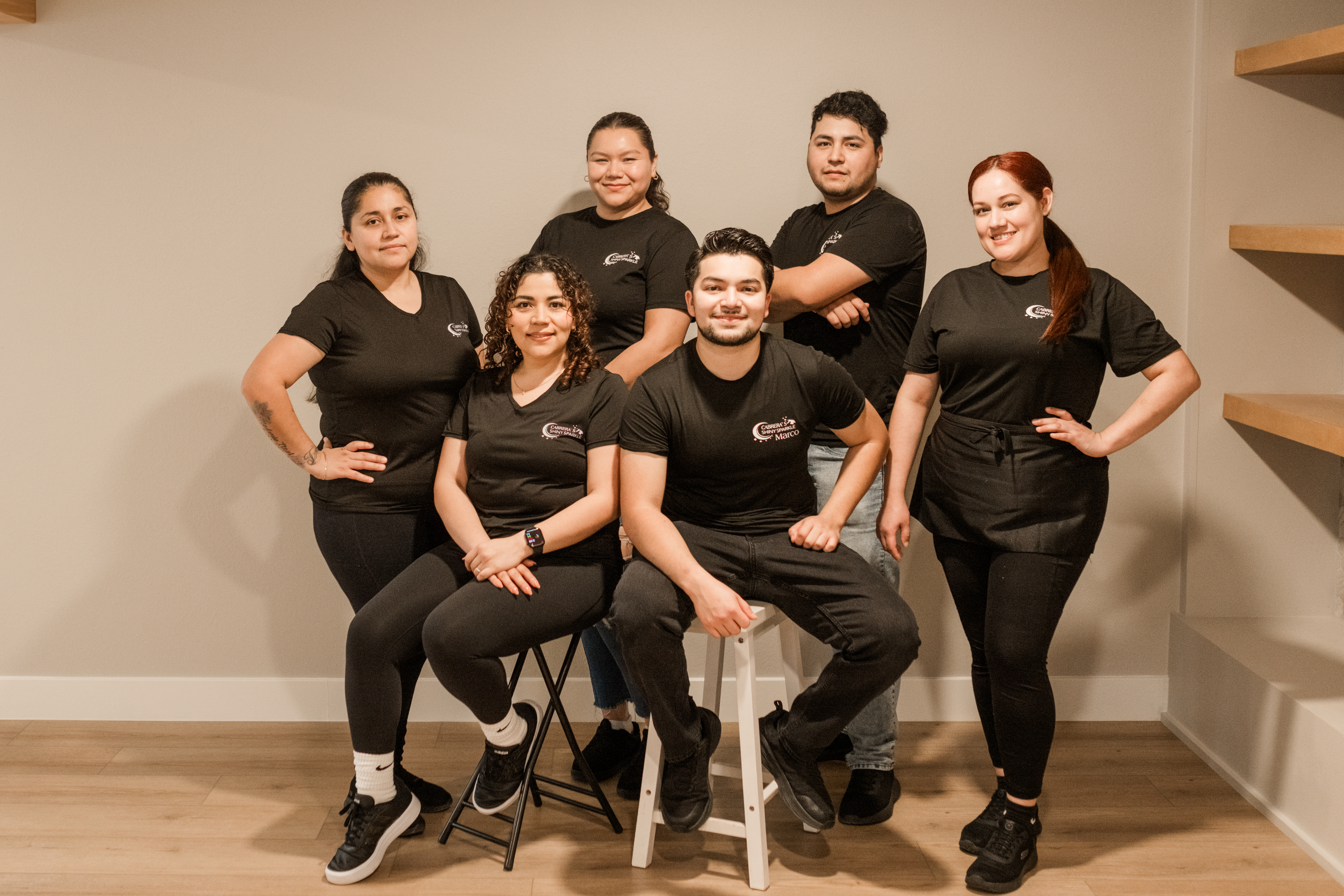 Smiling cleaning professional in apron holding cleaning supplies and a mop, showcasing Cabrera's Shiny Sparkle's commitment to residential and commercial cleaning in Portland.
