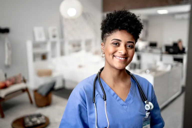 happy nurse in clinic wearing scrubs