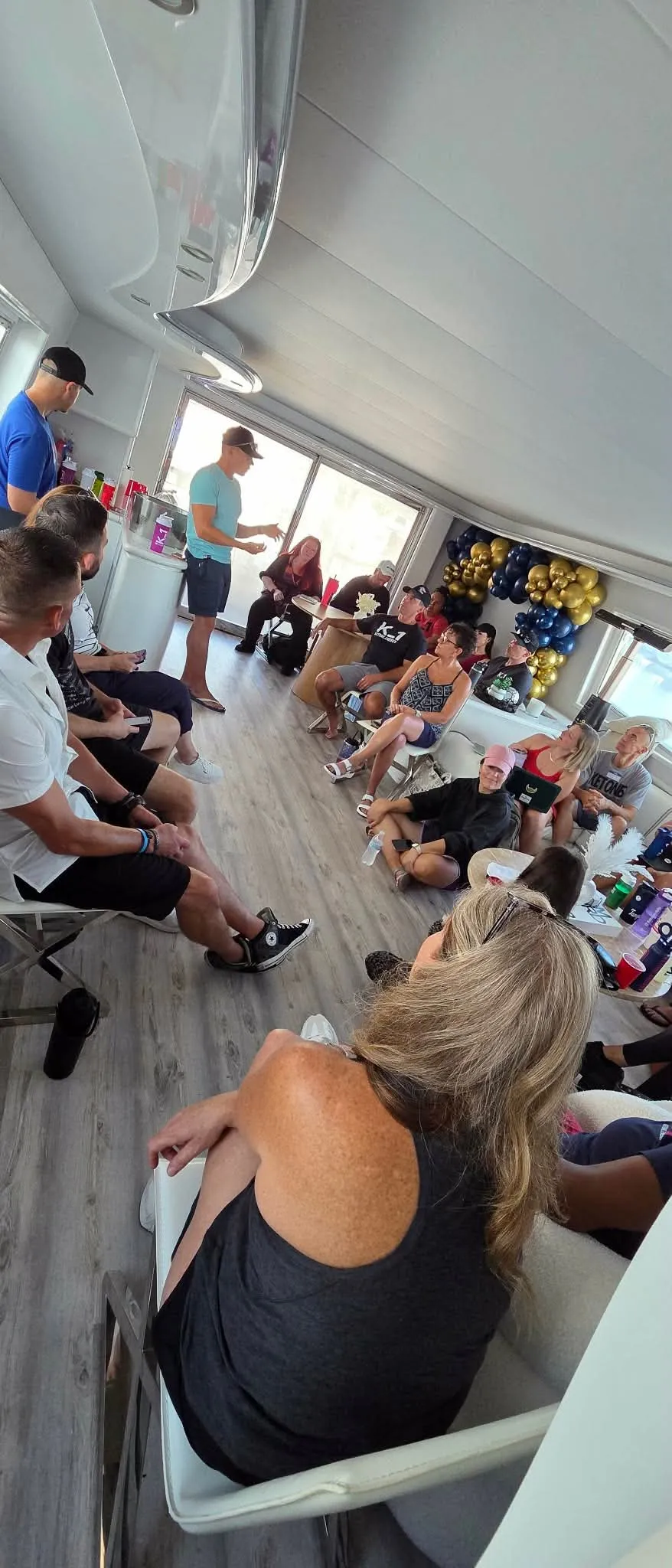 Momentum Pro team members sharing a group conversation aboard a boat