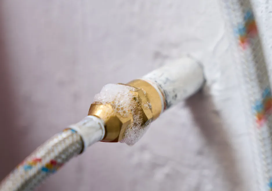 Licensed plumber inspecting an accessible gas line connection