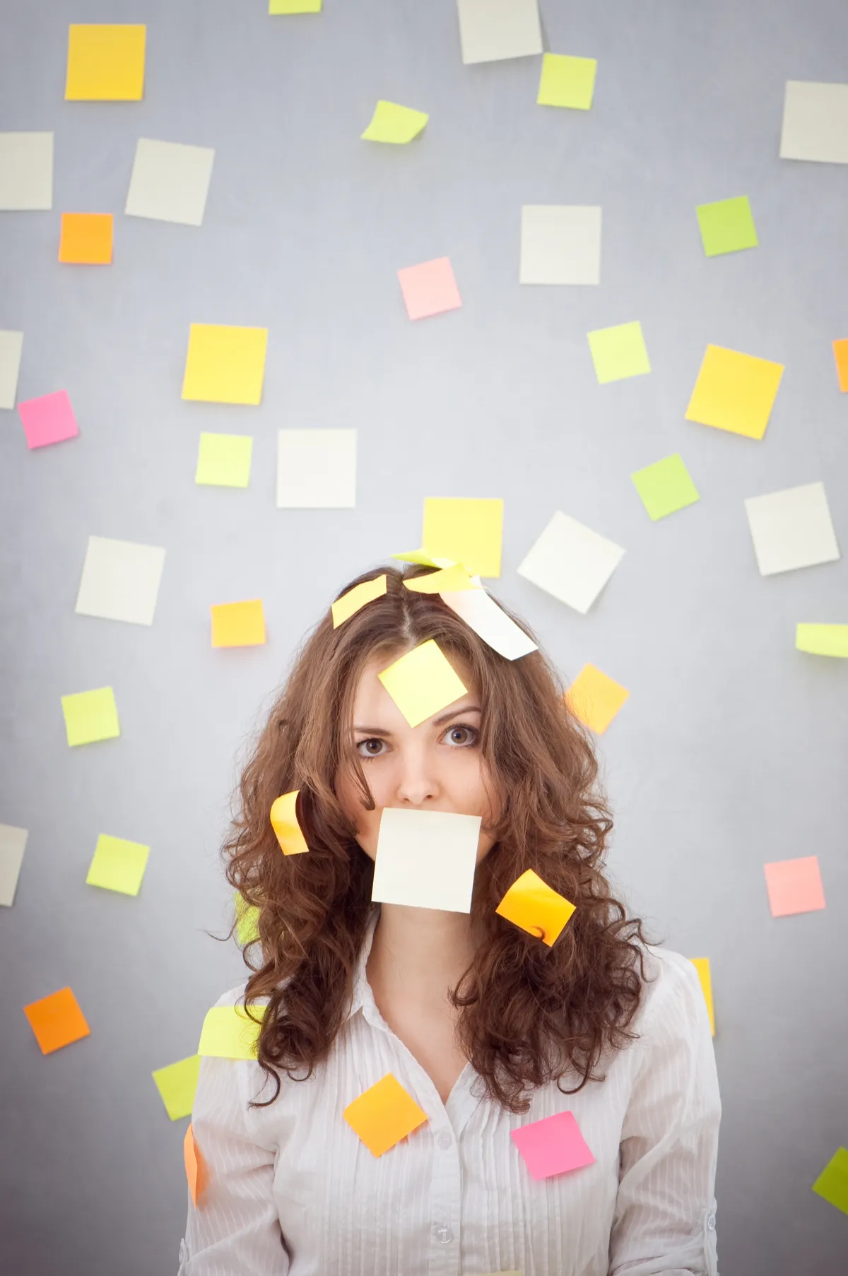 Woman surrounded by sticky notes representing tech overwhelm