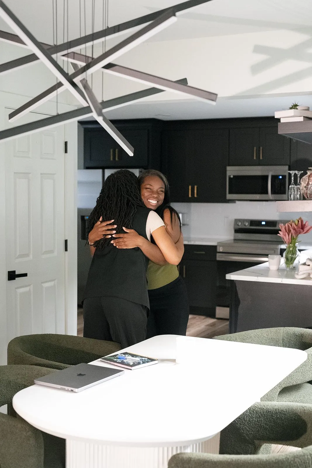 Two women sitting together with a laptop and printed materials