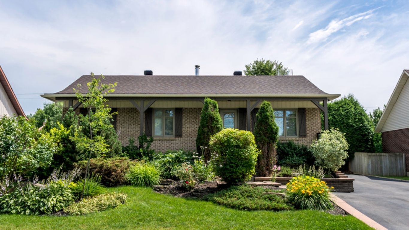 Brick bungalow with a mature tree and front lawn in an established Orleans neighbourhood in east Ottawa