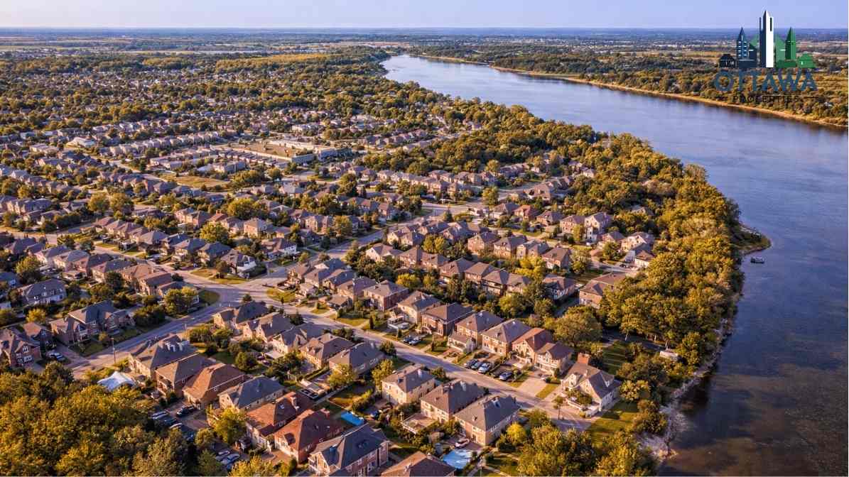 Aerial view of Ottawa residential neighborhood with modern homes, lush greenery, and a river, highlighting the community's layout and proximity to nature, relevant to Ottawa Properties real estate services.