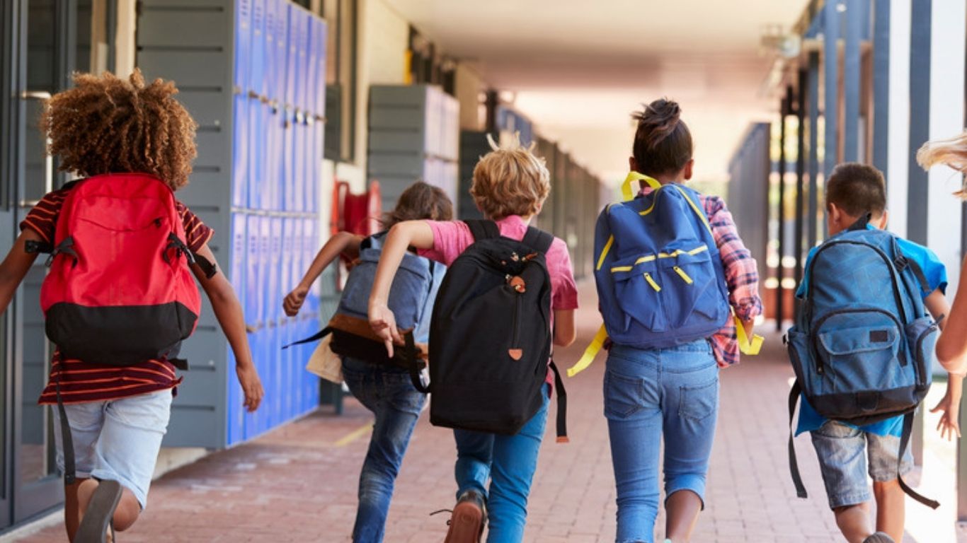 Children with backpacks running to school in a family neighbourhood in Orleans, Ottawa