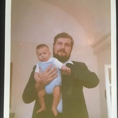 Matteo as a baby, held by his father