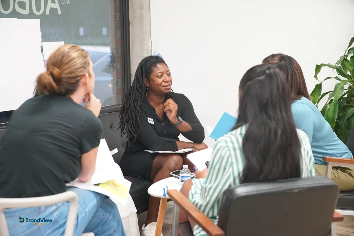 Three small business owners reviewing a printed roadmap on a bright table, natural midday light streaming in, modern office, candid top-down angle, photorealistic, conveys collaboration and clarity.