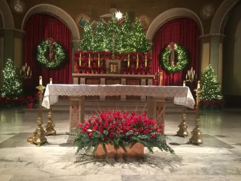 Magnificent church interior Christmas decor with wreaths, garlands, and candles radiating warmth and sacred holiday joy.