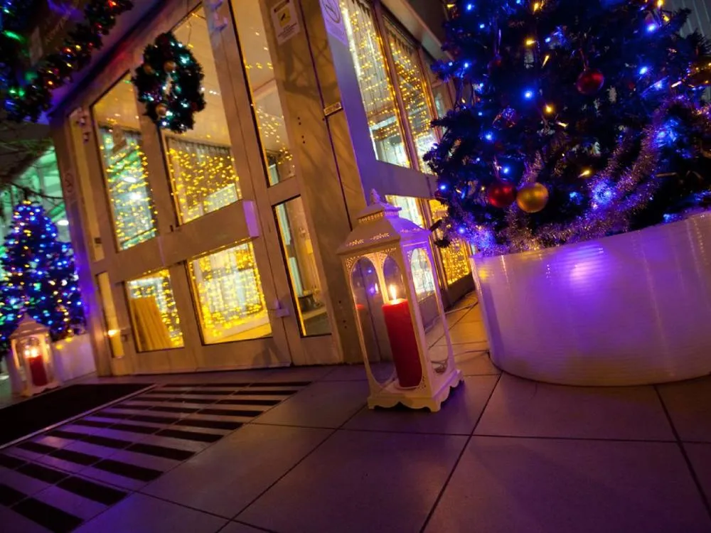 Hotel entrance showcasing stunning Christmas wreath designs with gold accents, pinecones, ribbons, and sparkling festive details.
