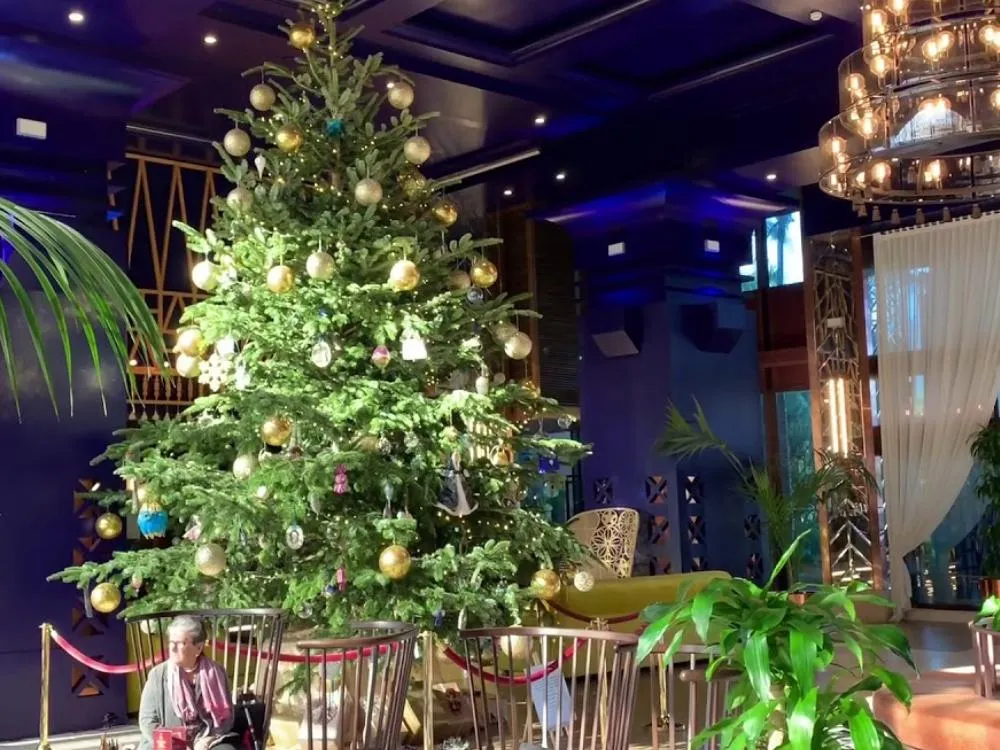 Sophisticated hotel ambiance featuring elegant Christmas decor, shimmering ornaments, lush wreaths, and candlelit luxury today.