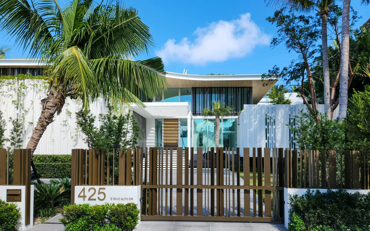south florida style modern home with thin wooden fencefront
