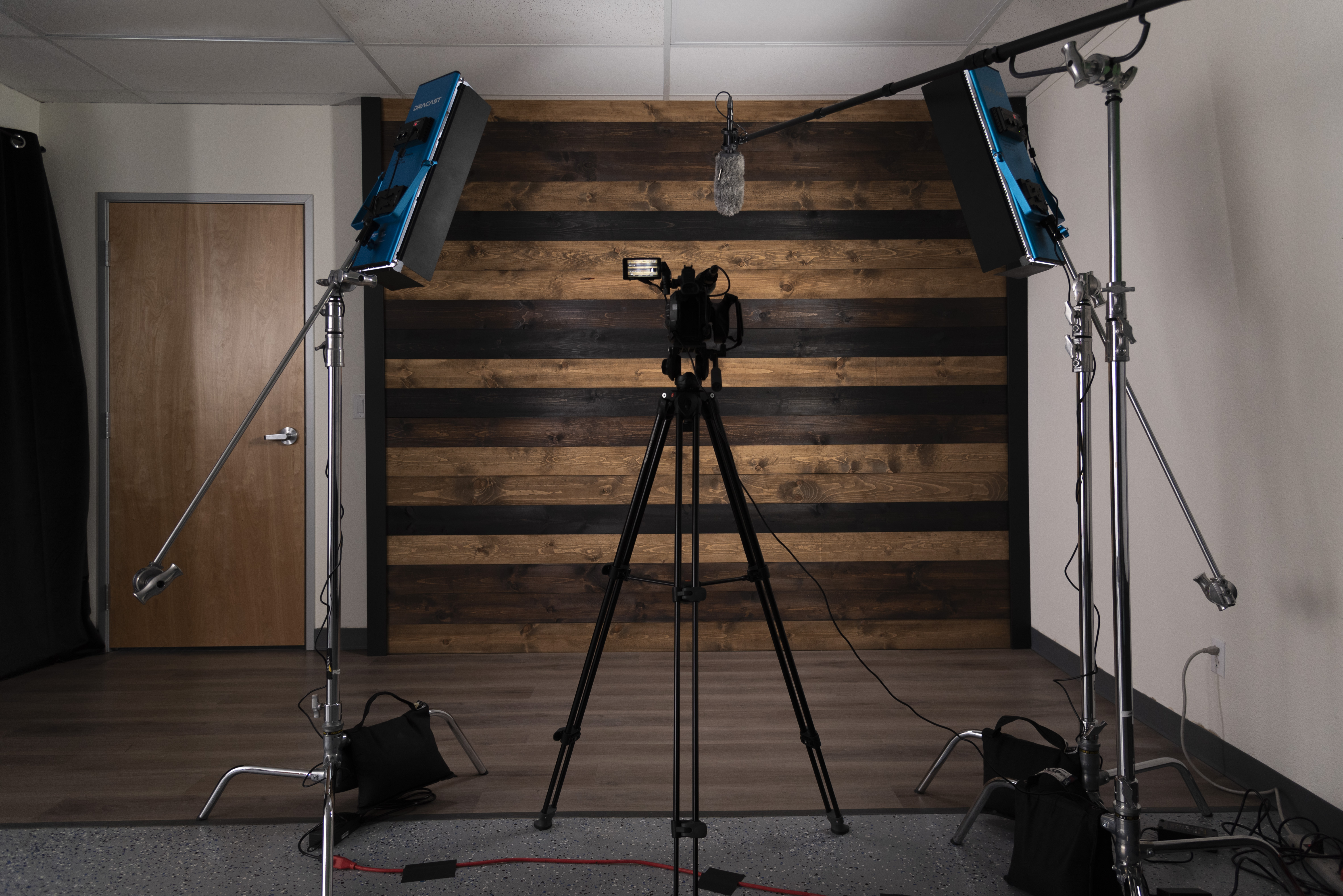 Wooden wall background with camera, microphone, and lighting set up