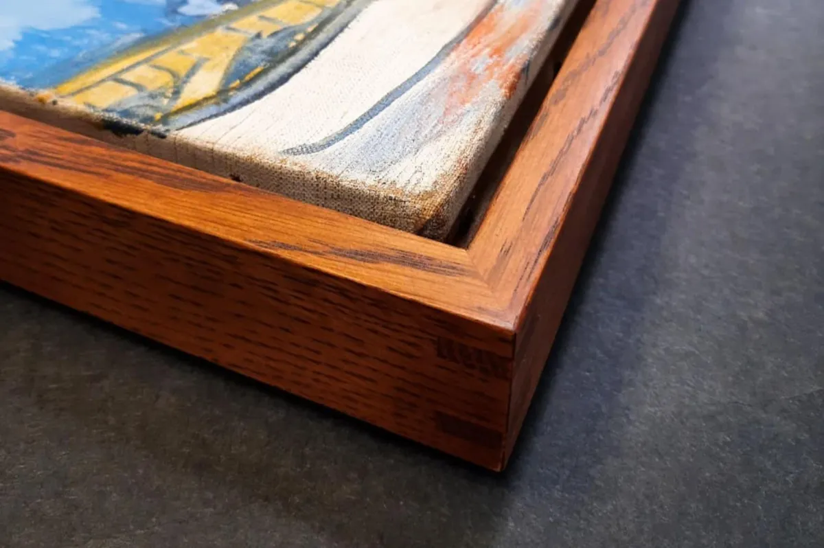 Close-up of canvas artwork set inside a handcrafted wood float frame