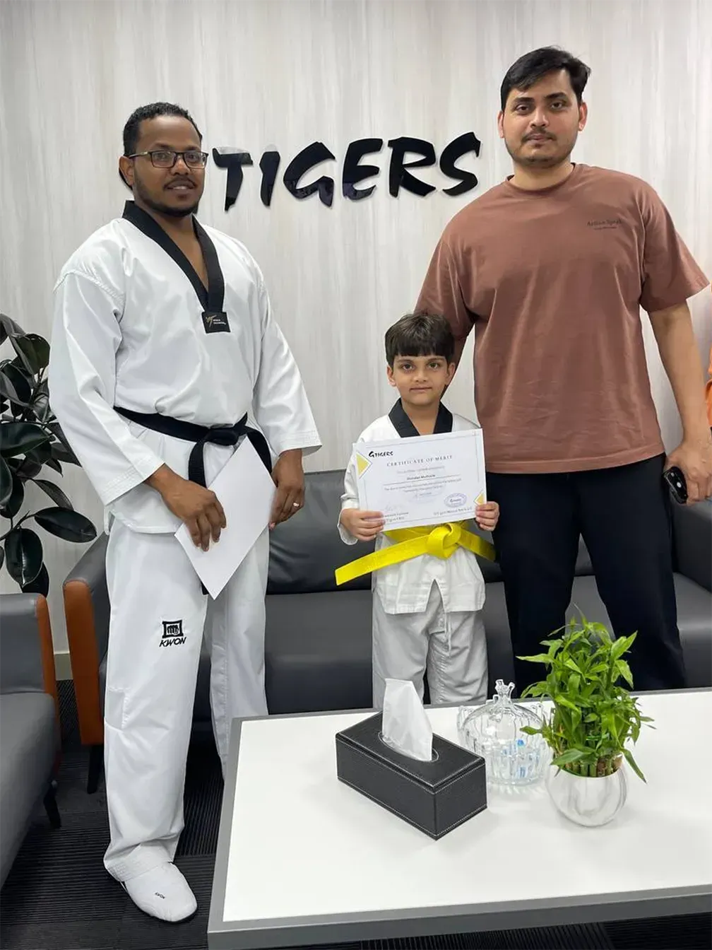 image - happy child with taekwondo instructor and parent