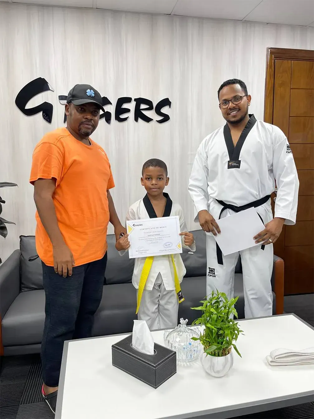 image - happy child with taekwondo instructor and parent